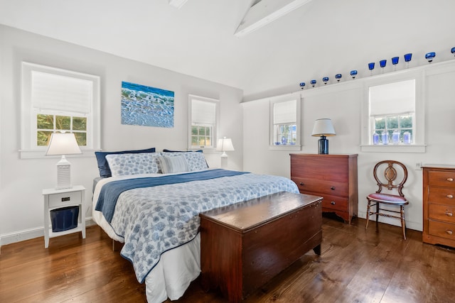 bedroom with hardwood / wood-style flooring, multiple windows, and vaulted ceiling