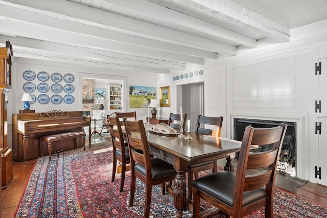 dining space featuring wood ceiling, beam ceiling, a fireplace, and wood finished floors