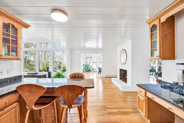 67 Redwood Cir, Mashpee, MA 02649 - dining space with light wood-style floors, a brick fireplace, and a baseboard radiator