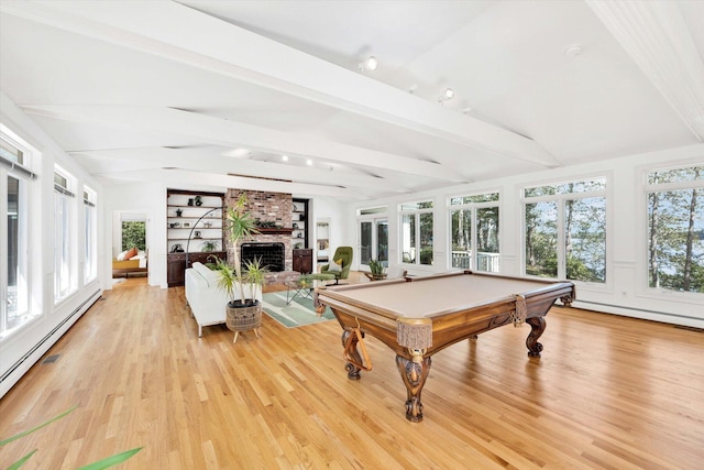 rec room with a wealth of natural light, a fireplace, lofted ceiling with beams, a baseboard radiator, and light wood-type flooring