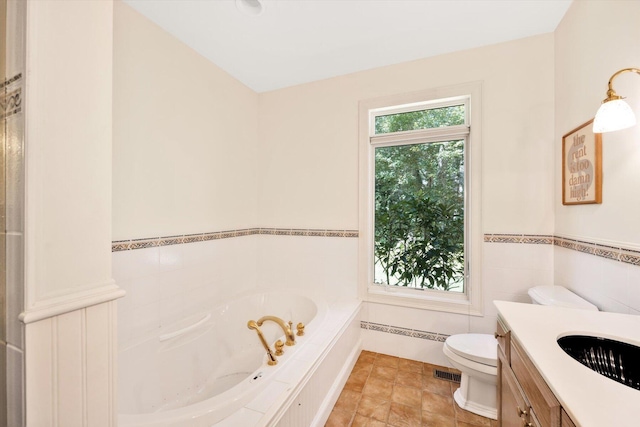 bathroom with vanity, a bathtub, tile walls, and toilet