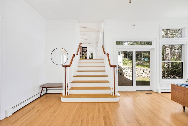 staircase with hardwood / wood-style floors, ornamental molding, and baseboard heating