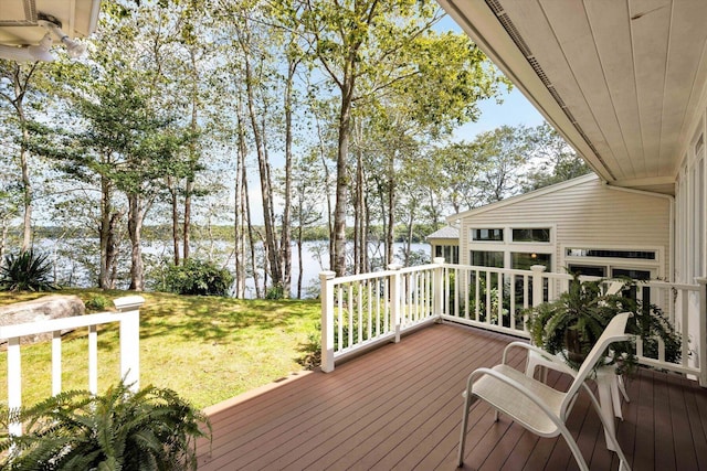 deck with a water view and a lawn