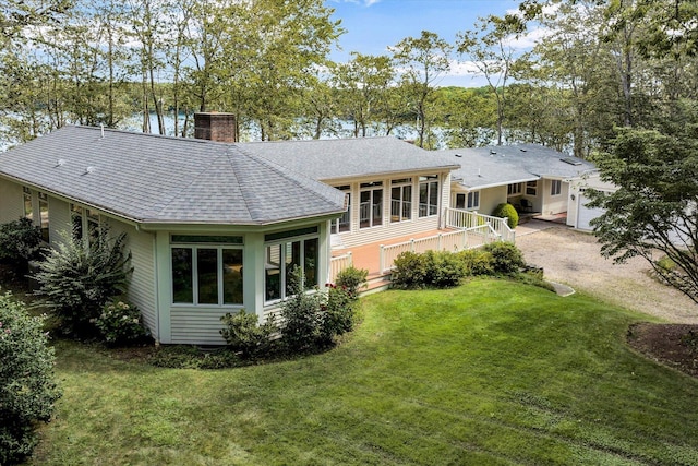 back of house featuring a sunroom and a yard