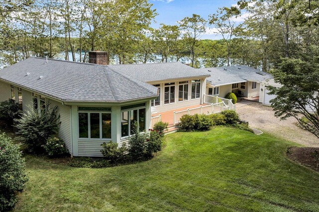67 Redwood Cir, Mashpee, MA 02649 - rear view of house featuring a chimney, a lawn, a shingled roof, dirt driveway, and an attached garage