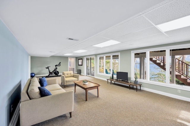 living room with carpet flooring and a paneled ceiling