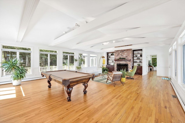 rec room with a brick fireplace, light hardwood / wood-style floors, and a healthy amount of sunlight