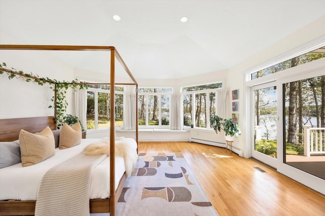 sunroom with lofted ceiling and a baseboard heating unit