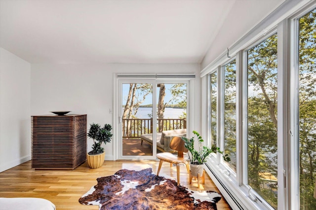 sunroom featuring a water view