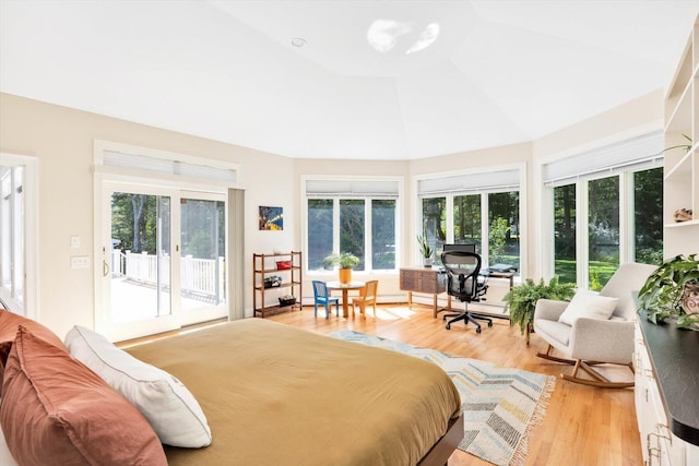 bedroom with multiple windows, lofted ceiling, access to exterior, and light wood-type flooring