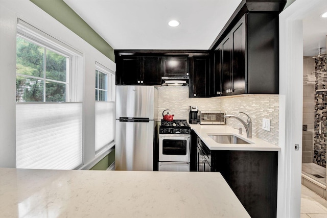 kitchen with stainless steel fridge, sink, backsplash, light tile patterned floors, and gas stove