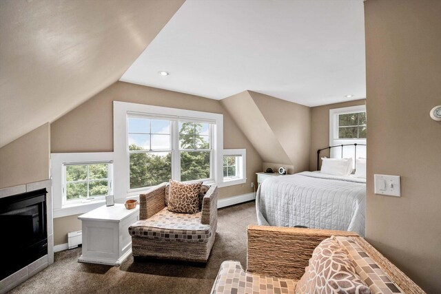 bedroom with a fireplace, a baseboard radiator, vaulted ceiling, and dark colored carpet