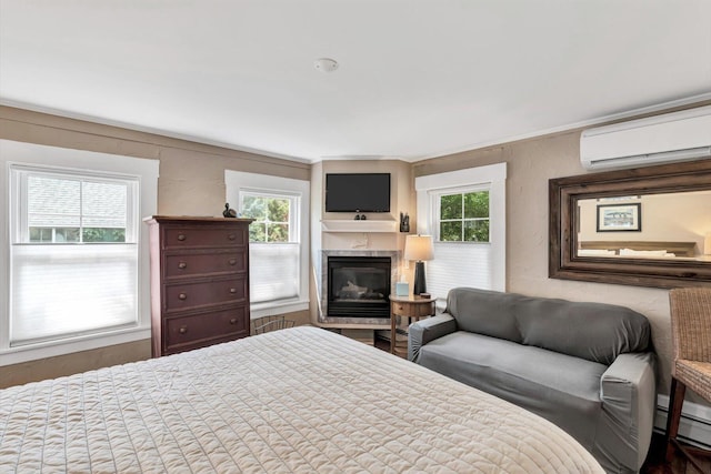 bedroom featuring multiple windows, a baseboard heating unit, a wall unit AC, and a premium fireplace