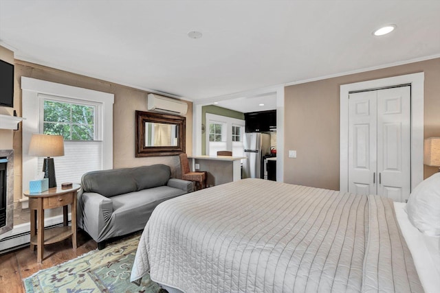 bedroom with crown molding, a wall mounted air conditioner, stainless steel refrigerator, a closet, and dark wood-type flooring