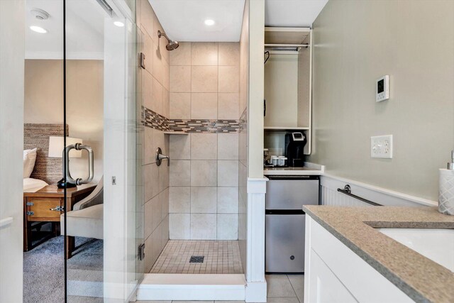 bathroom featuring tile patterned flooring, walk in shower, and vanity