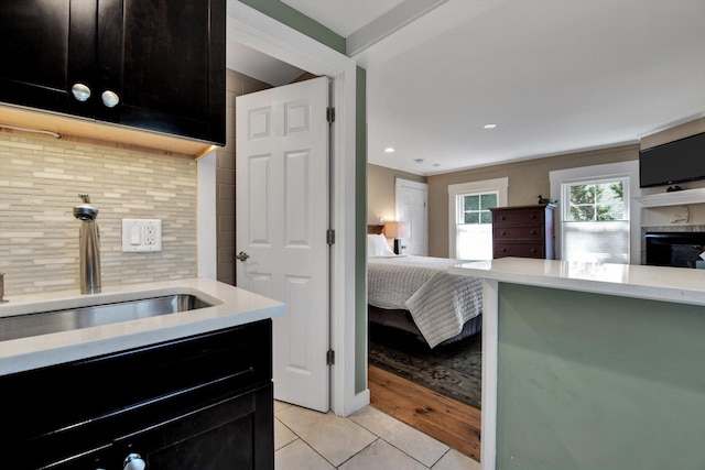 kitchen featuring sink, backsplash, and light tile patterned floors