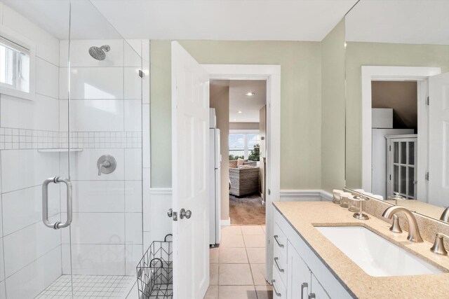 bathroom with vanity, a shower with shower door, and tile patterned flooring