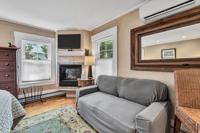 living room with a baseboard radiator, hardwood / wood-style floors, a fireplace, crown molding, and a wall mounted air conditioner