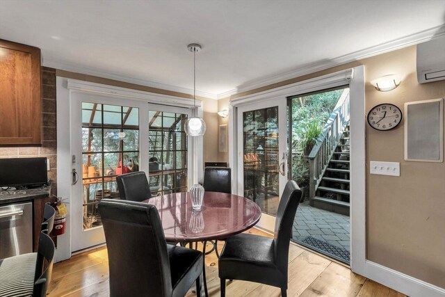 dining room with an AC wall unit, light hardwood / wood-style flooring, and ornamental molding