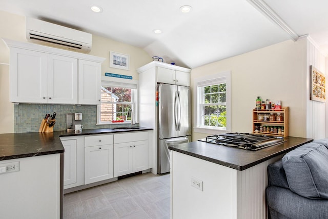 31 Chase St, Dennis Port, MA 02639 - kitchen with freestanding refrigerator, an AC wall unit, dark countertops, gas cooktop, and white cabinets