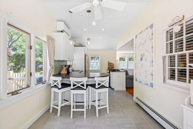 31 Chase St, Dennis Port, MA 02639 - kitchen with a baseboard radiator, dark countertops, plenty of natural light, a peninsula, and recessed lighting