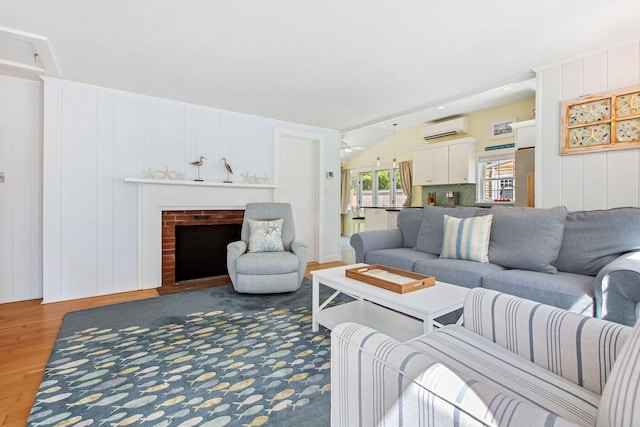 31 Chase St, Dennis Port, MA 02639 - living room featuring a wall mounted AC, wood finished floors, and a fireplace