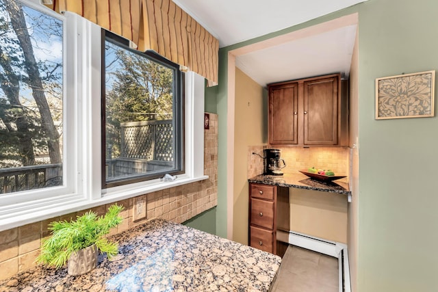 kitchen with tile patterned floors, dark stone counters, and tasteful backsplash