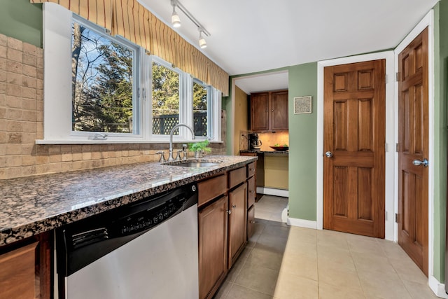 kitchen with sink, backsplash, stainless steel dishwasher, a baseboard heating unit, and light tile patterned floors
