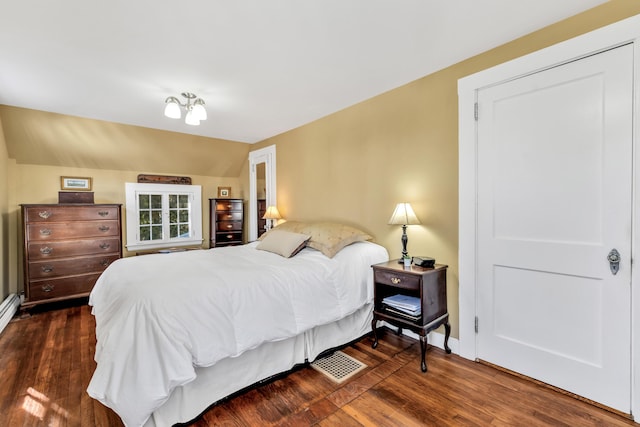 bedroom with vaulted ceiling and dark hardwood / wood-style floors