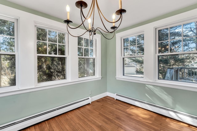 unfurnished dining area with hardwood / wood-style floors, a chandelier, and baseboard heating