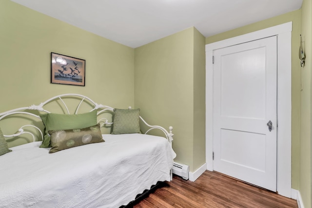 bedroom featuring dark hardwood / wood-style floors and a baseboard heating unit