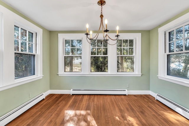 unfurnished dining area with hardwood / wood-style flooring and a baseboard heating unit