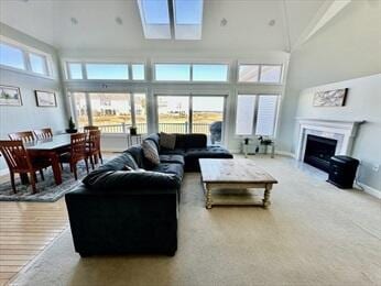 carpeted living room featuring a high ceiling, baseboards, and a fireplace