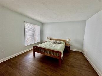 bedroom featuring baseboards and wood finished floors