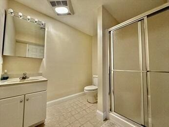 bathroom featuring toilet, visible vents, vanity, baseboards, and a stall shower