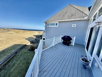 wooden deck with a yard and a grill