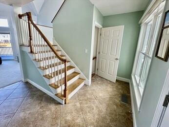 staircase with visible vents and baseboards