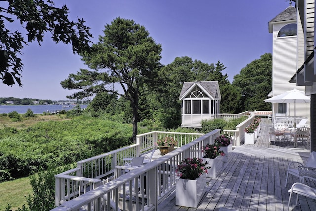 wooden terrace featuring a sunroom and a water view