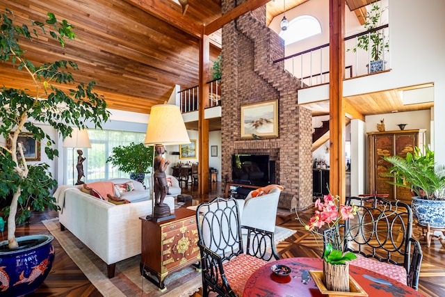 living room with a brick fireplace, a high ceiling, and parquet floors