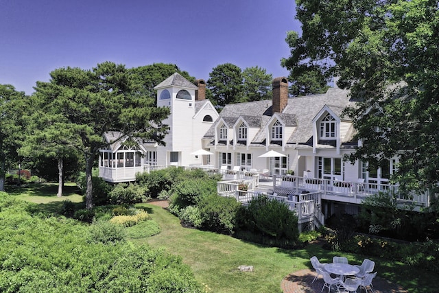 rear view of property featuring a lawn and a wooden deck