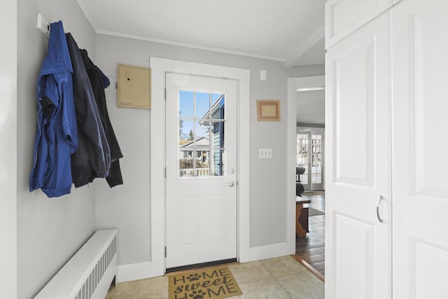 mudroom featuring radiator heating unit, ornamental molding, and light tile patterned flooring