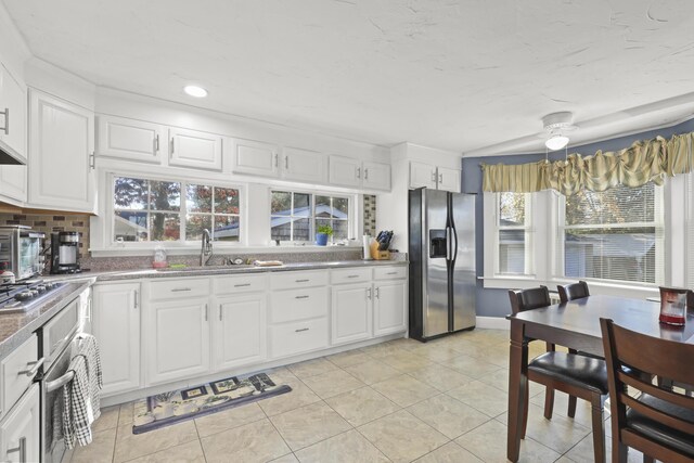 kitchen with white cabinets, light tile patterned floors, and stainless steel appliances