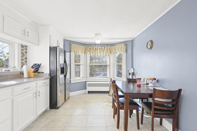 dining area featuring radiator and light tile patterned floors