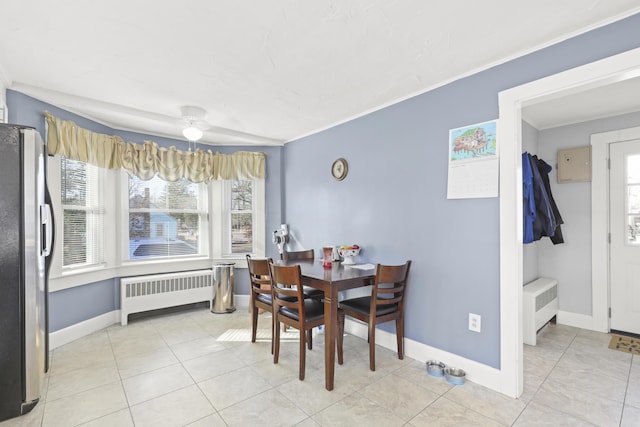 tiled dining room featuring radiator heating unit