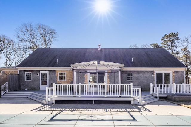 rear view of property with a deck and a patio