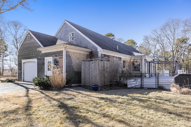 view of home's exterior featuring a lawn, driveway, a gate, fence, and a garage