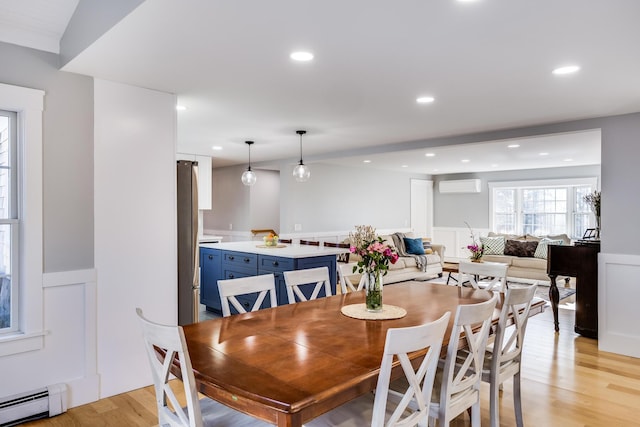 dining room with recessed lighting, a wall mounted AC, light wood-style floors, and a baseboard radiator