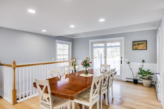 dining room featuring recessed lighting, baseboard heating, light wood-style flooring, and wainscoting