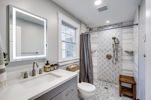 full bathroom with visible vents, toilet, a tile shower, recessed lighting, and vanity