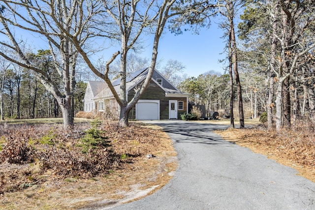 shingle-style home featuring a garage and driveway